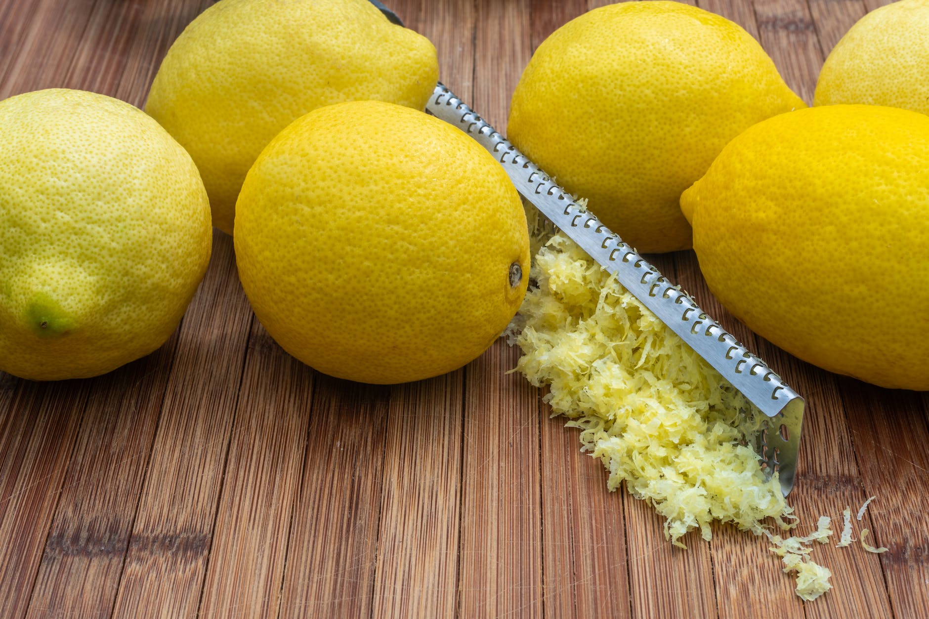 ripe lemons with zest and grater on table